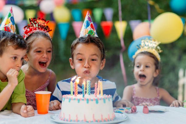 Child blowing candles on a birthday cake